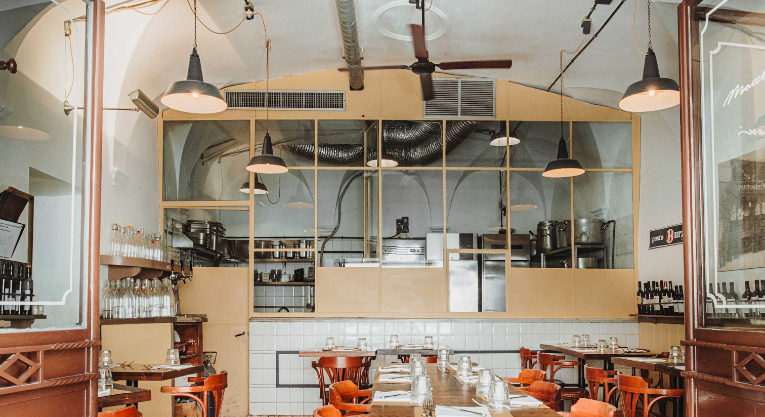 Maccheroni’s open kitchen with glass panels and hanging lamps
